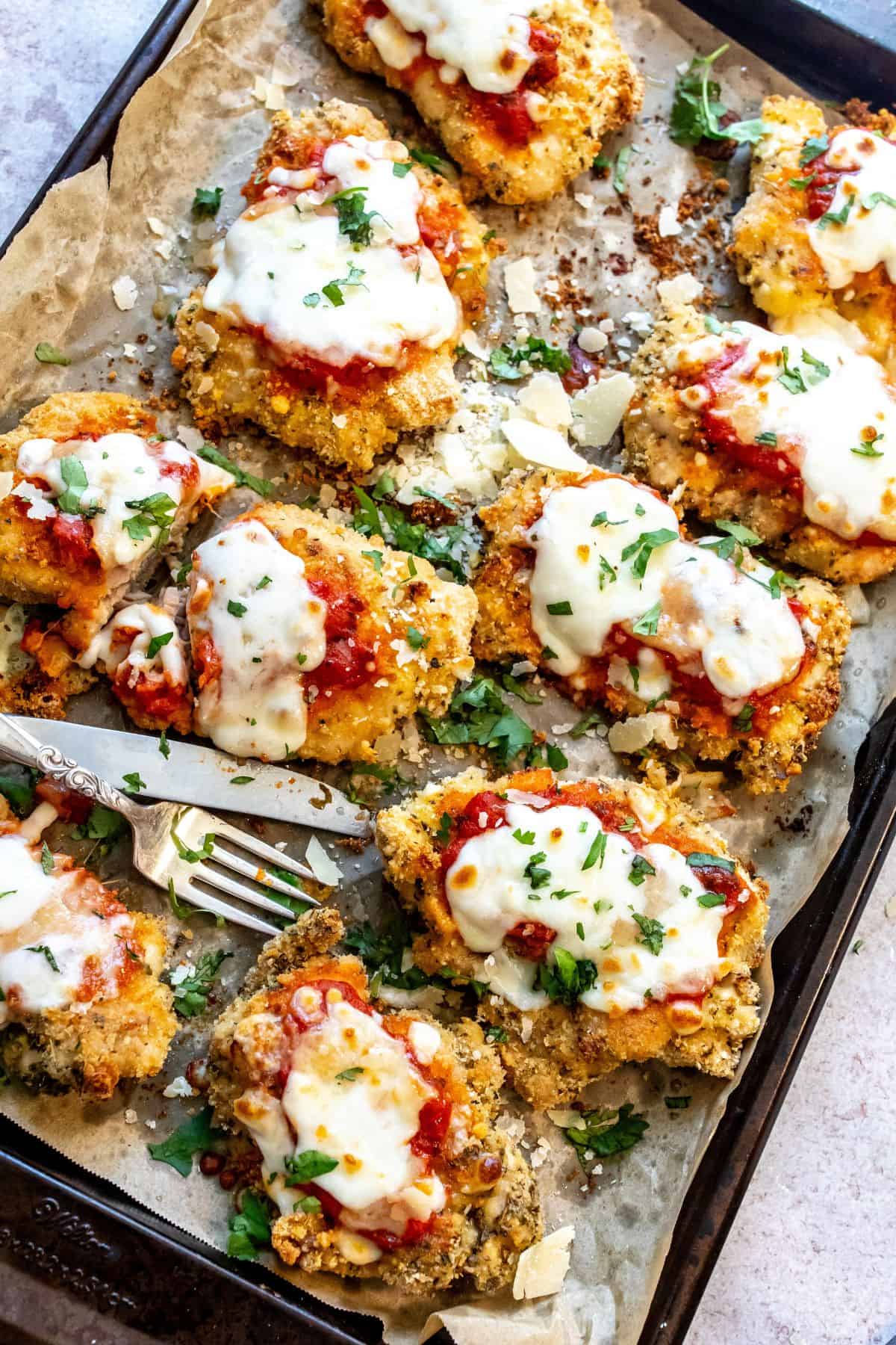 Parmesan Chicken Thighs on a baking sheet with parchment paper. 