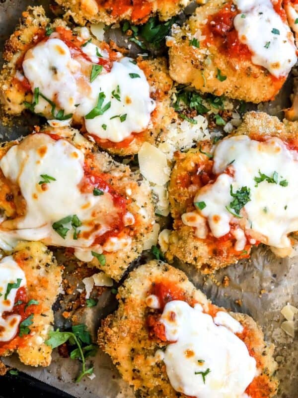 Parmesan Chicken Thighs on a baking sheet with parchment paper.