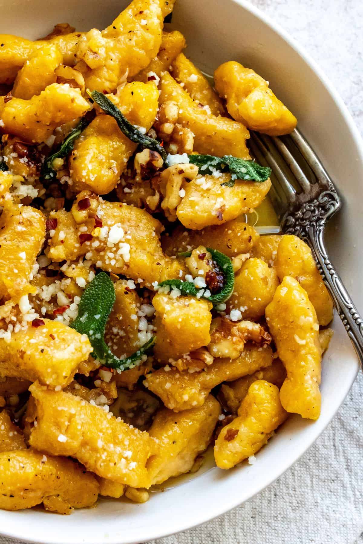 An image of butternut squash in a bowl with a fork on the side.