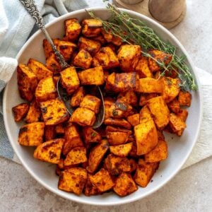 Crispy Roasted Sweet Potatoes in a bowl with a silver antique spoon.