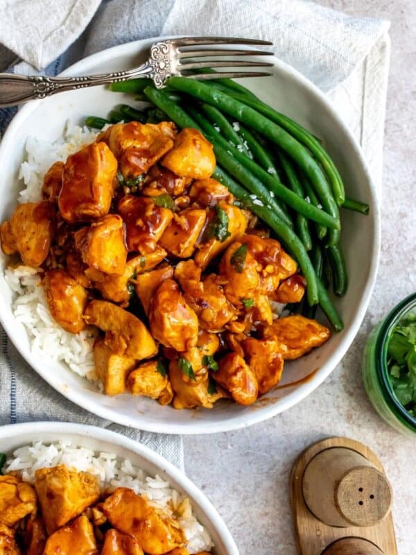 white bowl with Honey Bourbon Chicken and green beans.