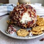 Up close photo of goat cheese ball with crackers on the side.