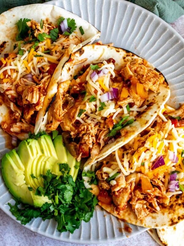 Plate with lines on it and three slow cooker chicken tacos.