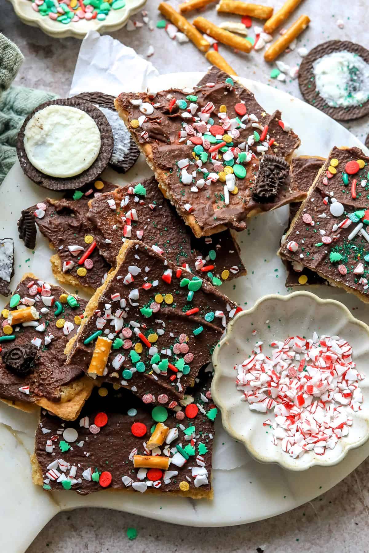 Christmas Bark on a white plate with sprinkles and Oreo cookies. 