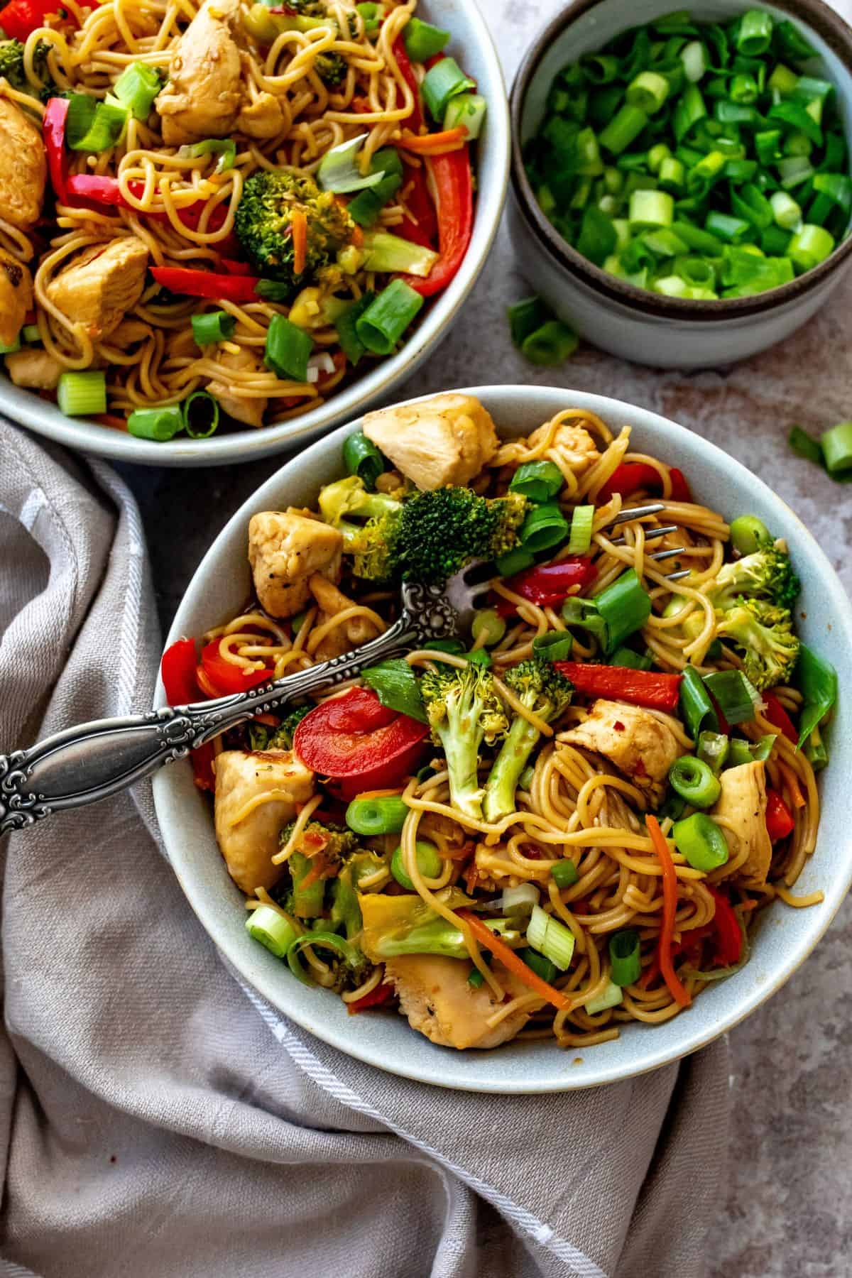 Teriyaki Chicken Ramen in a grey bowl with a dish towel on the side. 