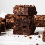 Chocolate Chocolate Chip Cookie Bars on a white counter, stacked up on each other.