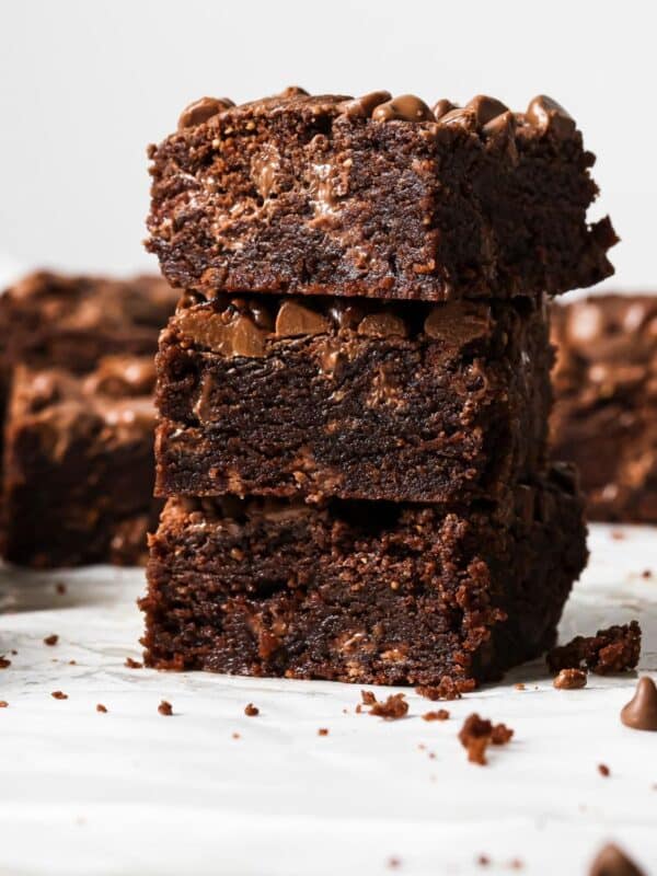 Chocolate Chocolate Chip Cookie Bars on a white counter, stacked up on each other.