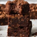 Chocolate Chocolate Chip Cookie Bars on a white counter, stacked up on each other.