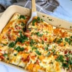 Cheesy White Enchiladas in a baking dish with bubbly cheese and cilantro.