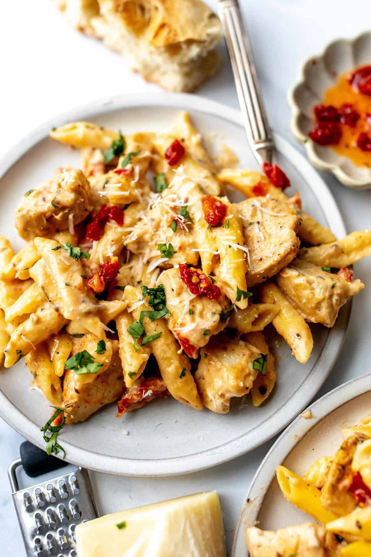 White ceramic plate with marry me chicken pasta on it and silver fork to the side. 