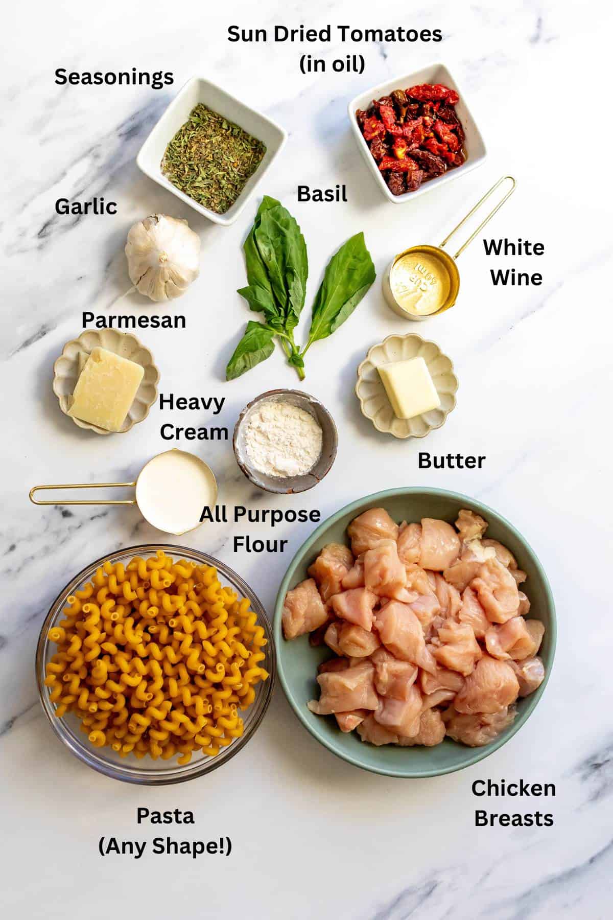 Ingredients needed to make the recipe on a white marble counter in bowls and on plates. 