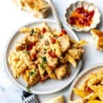 White ceramic plate with marry me chicken pasta on it and silver fork to the side.