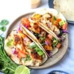 Grey plate with Blackened Fish Tacos on it and a blue towel to the side.