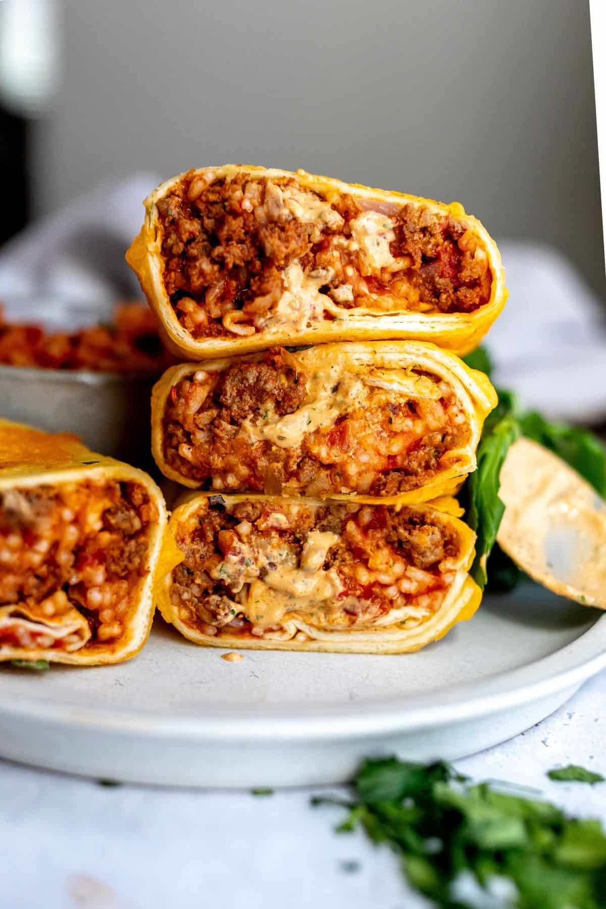 An image of grilled cheese burrito stacked on a plate.