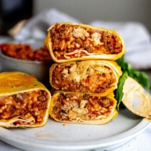 An image of grilled cheese burrito stacked on a plate.
