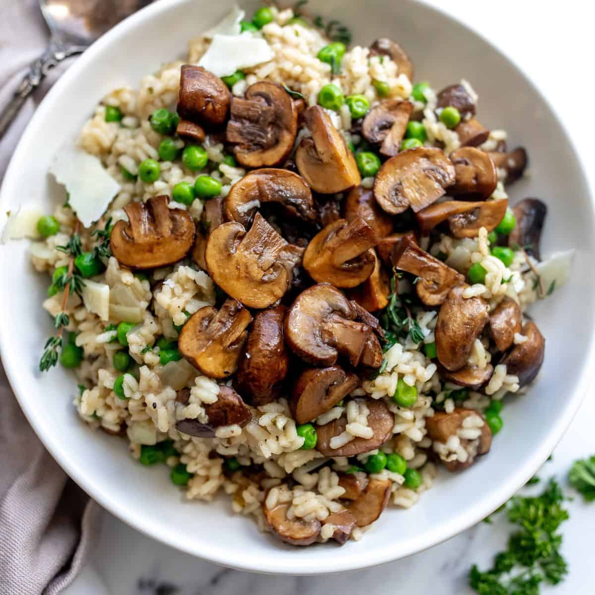 An overhead image of mushroom pea risotto in a bowl.