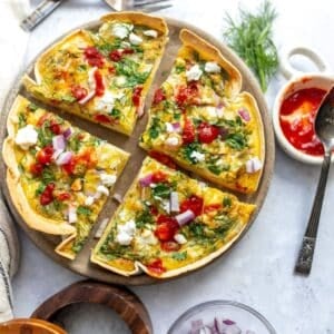An overhead image of the tortilla quiche bake sliced in four on a serving plate.