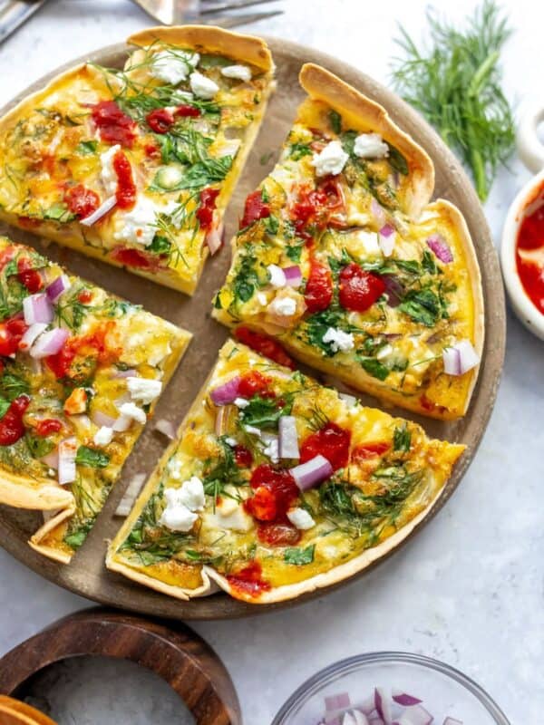 An overhead image of the tortilla quiche bake sliced in four on a serving plate.