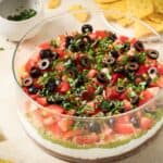 A close up image of 7 layer dip in a bowl.