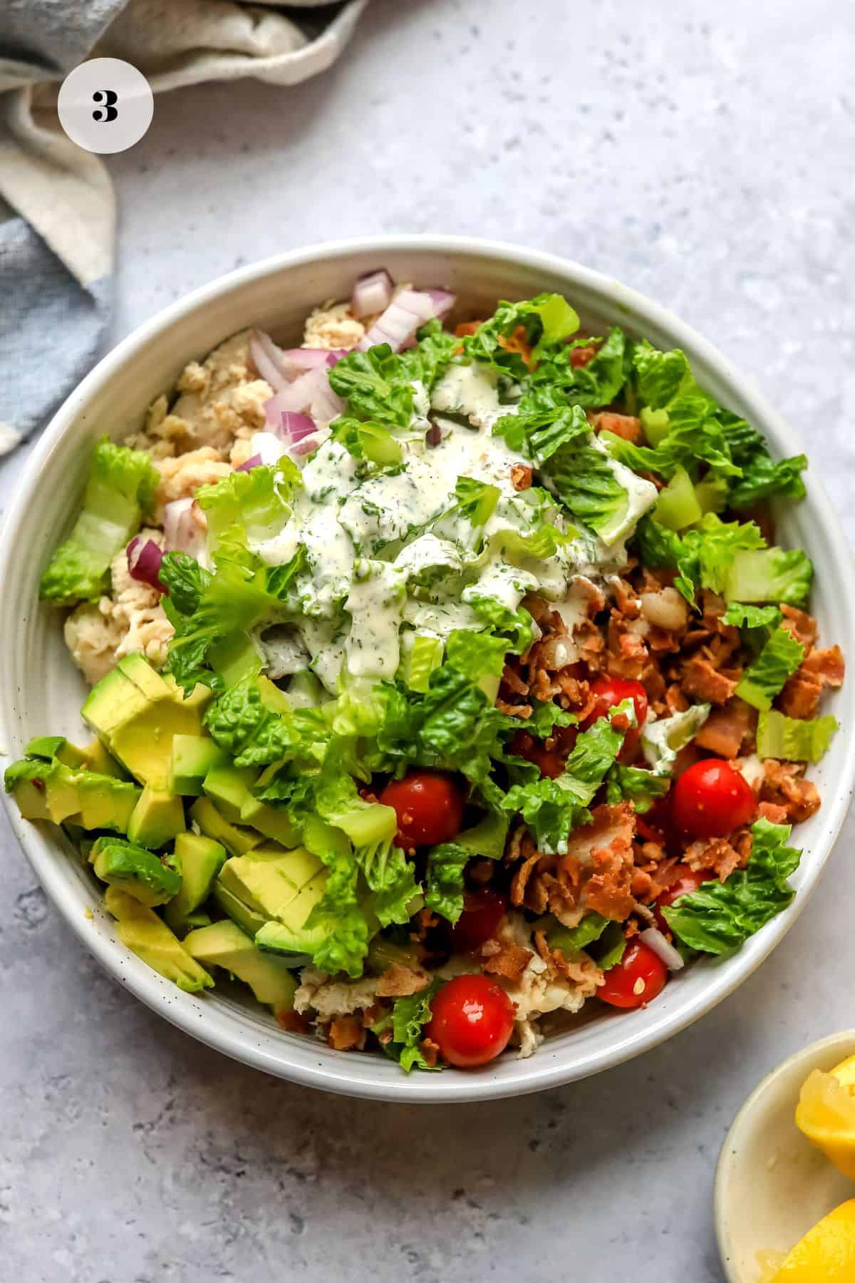 White bowl with BLT chicken salad in it before it's mixed.