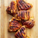 blackened chicken on a wooden cutting board.
