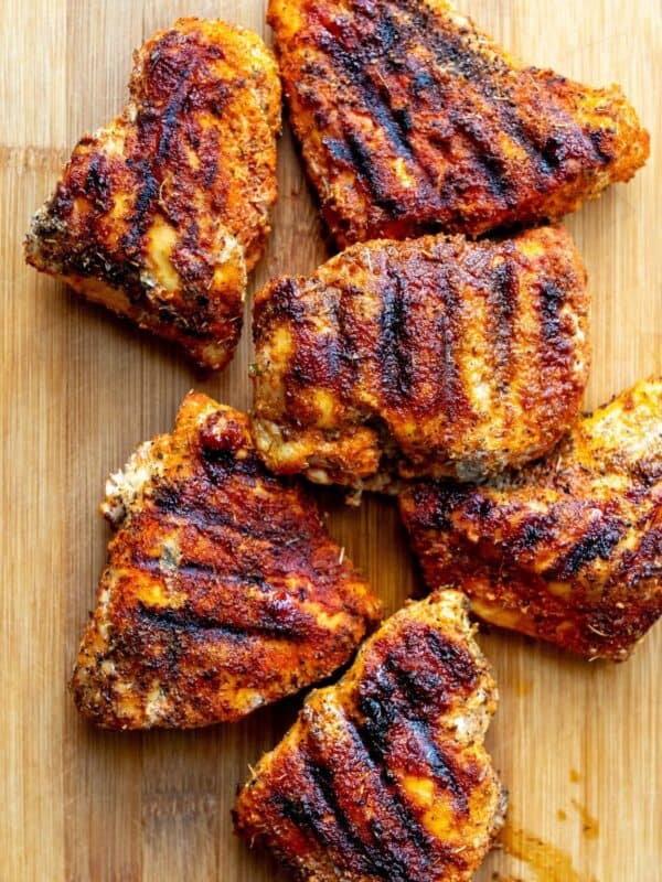 blackened chicken on a wooden cutting board.