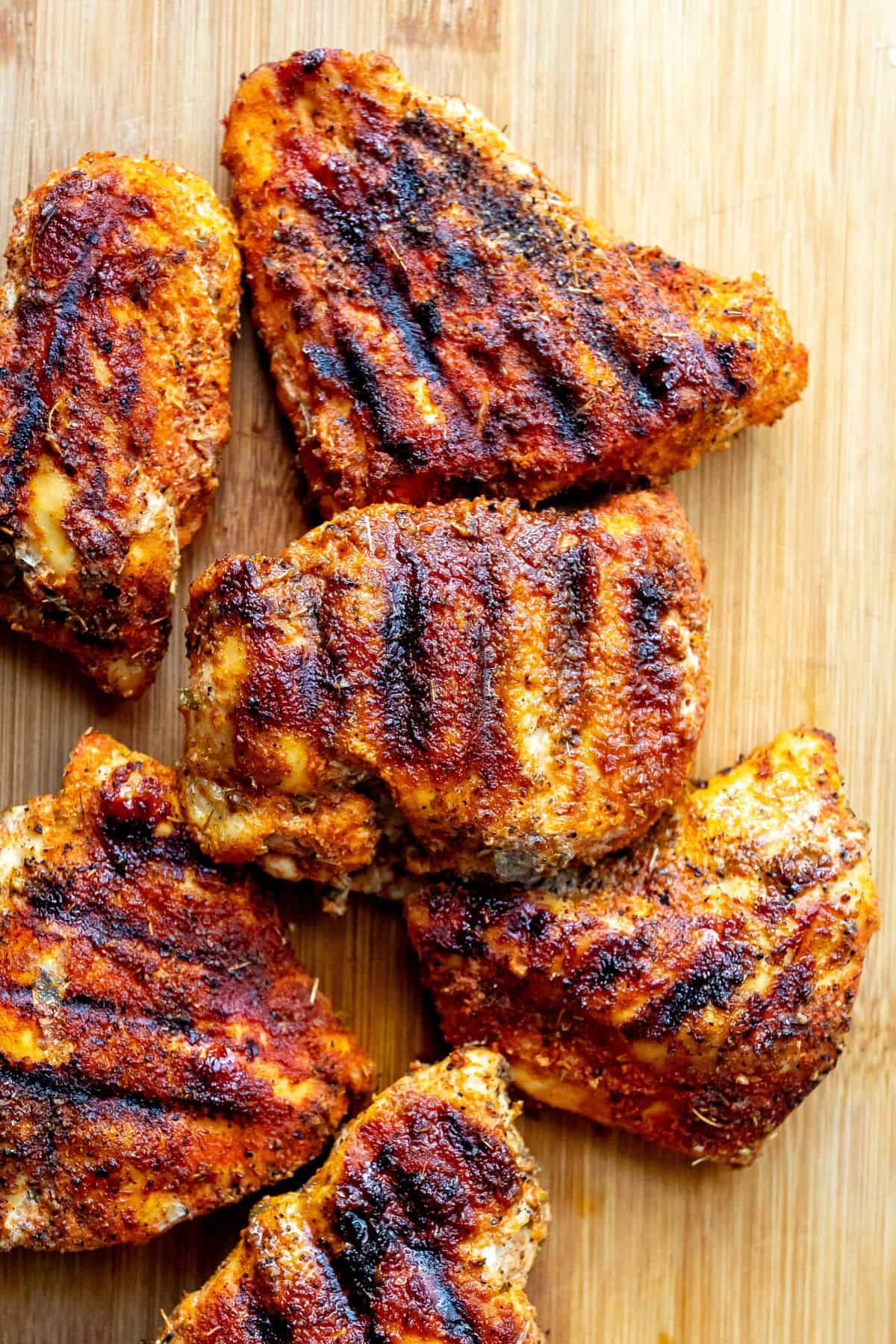 blackened chicken on a wooden cutting board.
