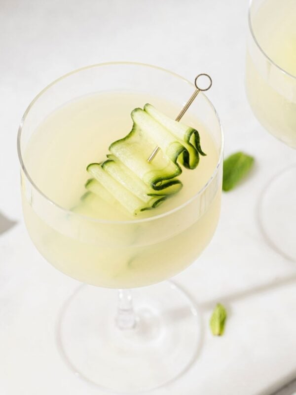Refreshing cucumber martini cocktail in a stemmed glass, garnished with cucumber ribbons—an easy cucumber martini recipe perfect for summer.