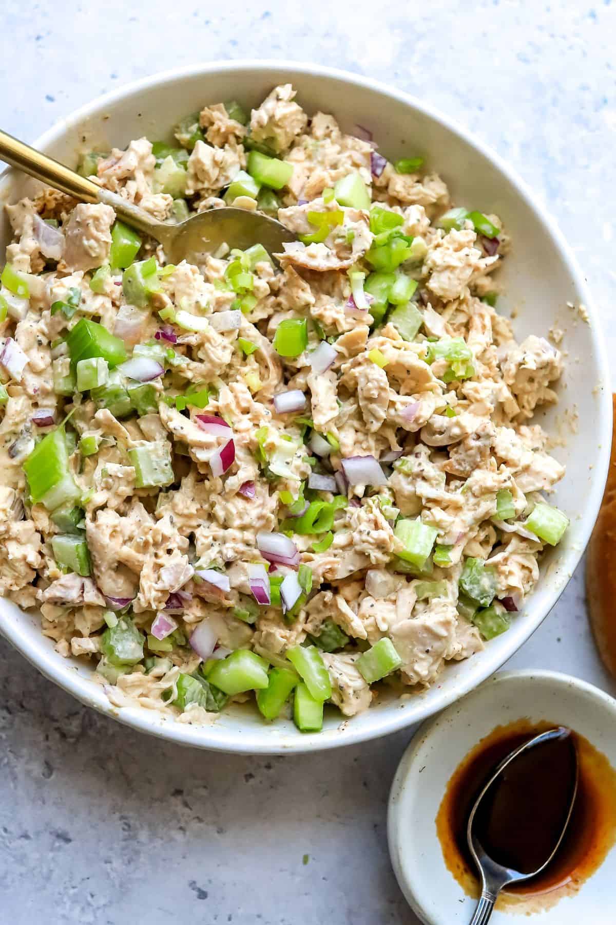 White bowl with smoked chicken salad in it with celery.