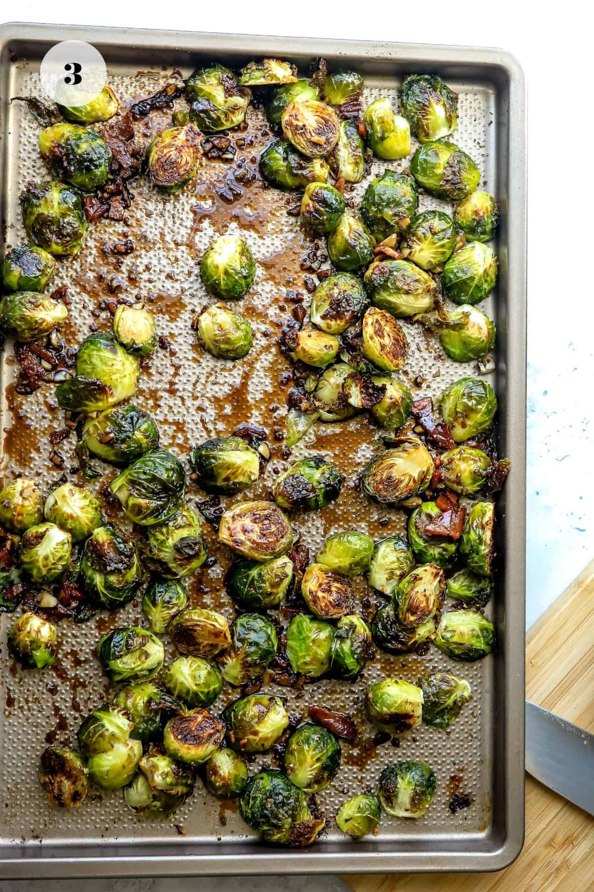 Baking sheet with brussel sprouts on top.