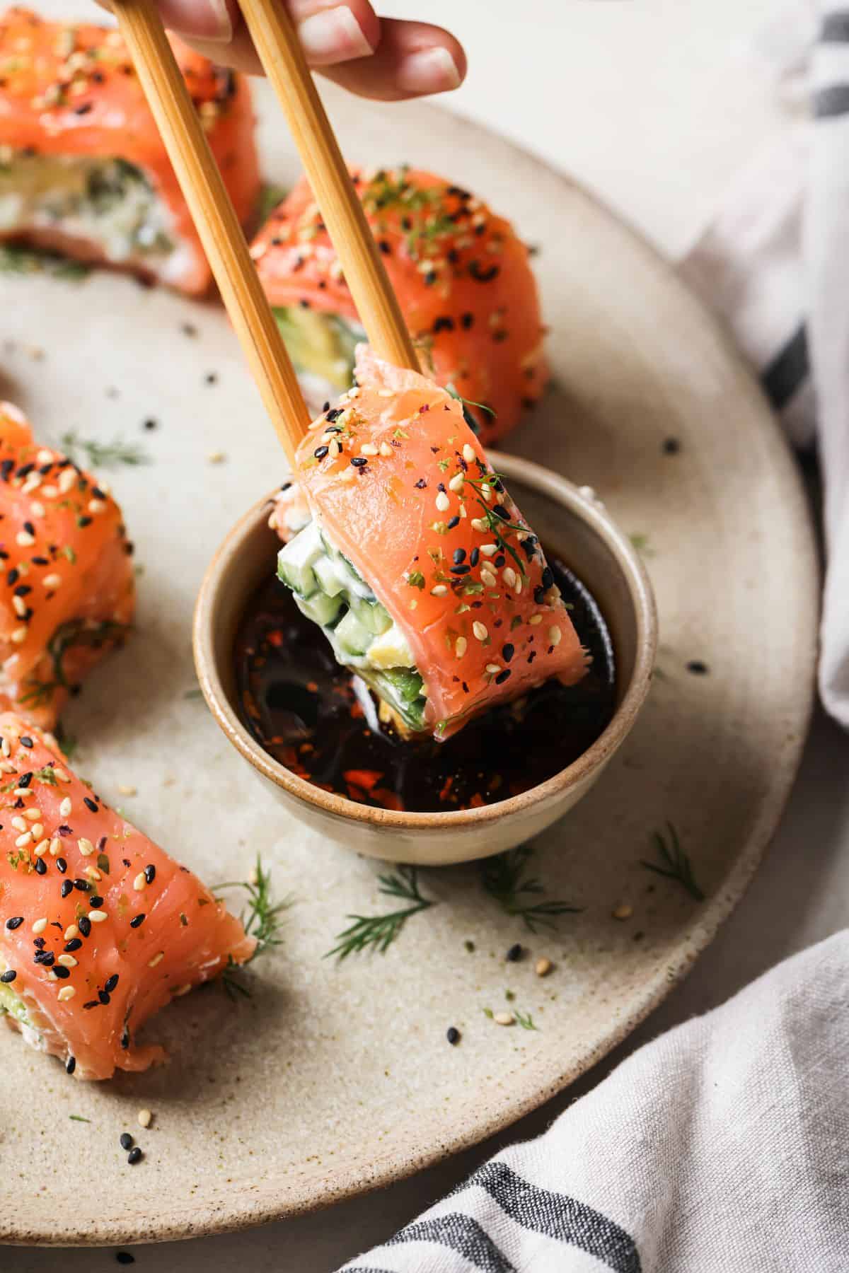 Salmon Avocado Roll on a plate being dipped into soy sauce