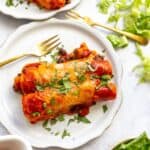 Vegetarian enchiladas on a plate with a gold fork.