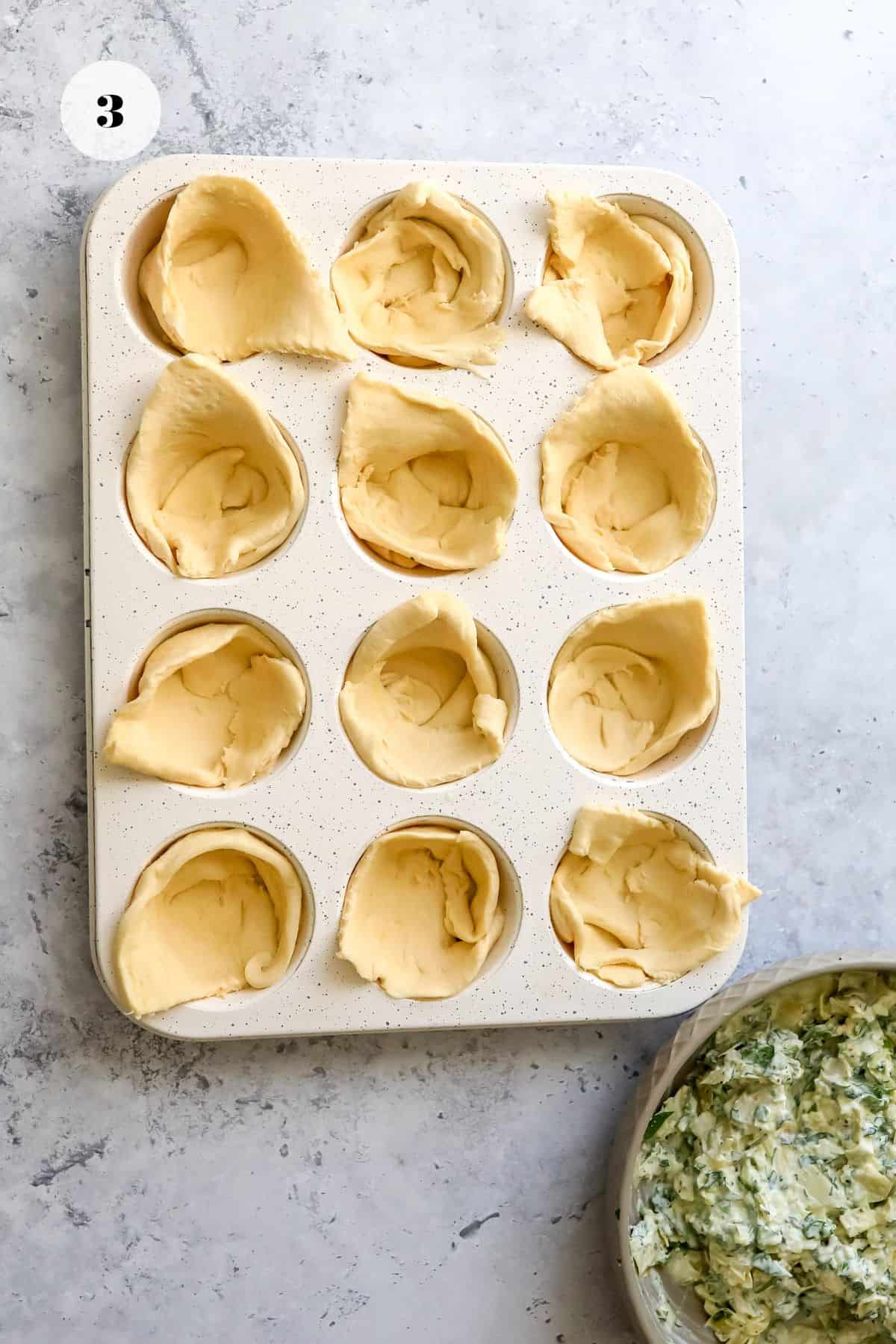 Crescent rolls in a muffin tin.