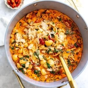 Grey bowl with Marry Me Chicken Soup in it and noodles off to the side.