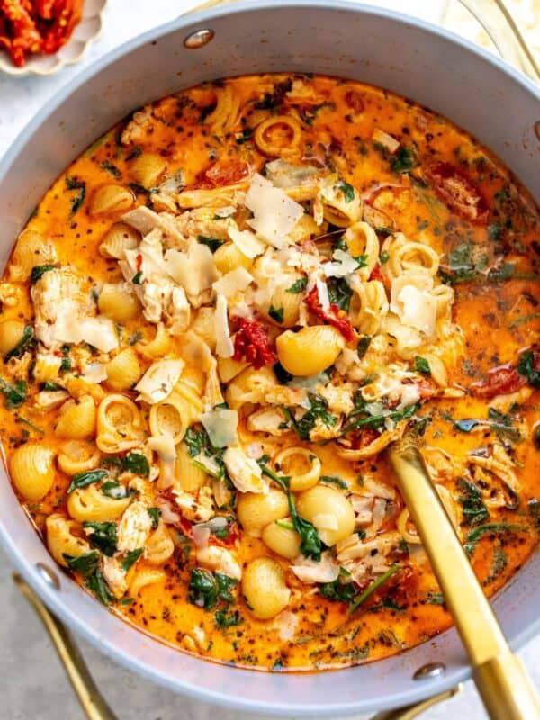 Grey bowl with Marry Me Chicken Soup in it and noodles off to the side.