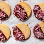 Peppermint Chocolate Dipped Shortbread on parchment paper in a row.