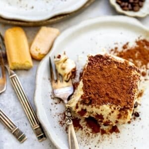 Tiramisu sliced in a baking dish with layers.