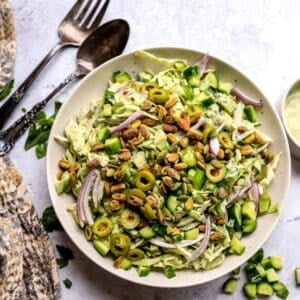 Green Goddess Salad recipe in a larger serving bowl with dressing to the side.