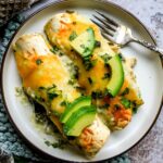 Poblano Chicken Enchiladas on a small plate with a silver fork to the side.