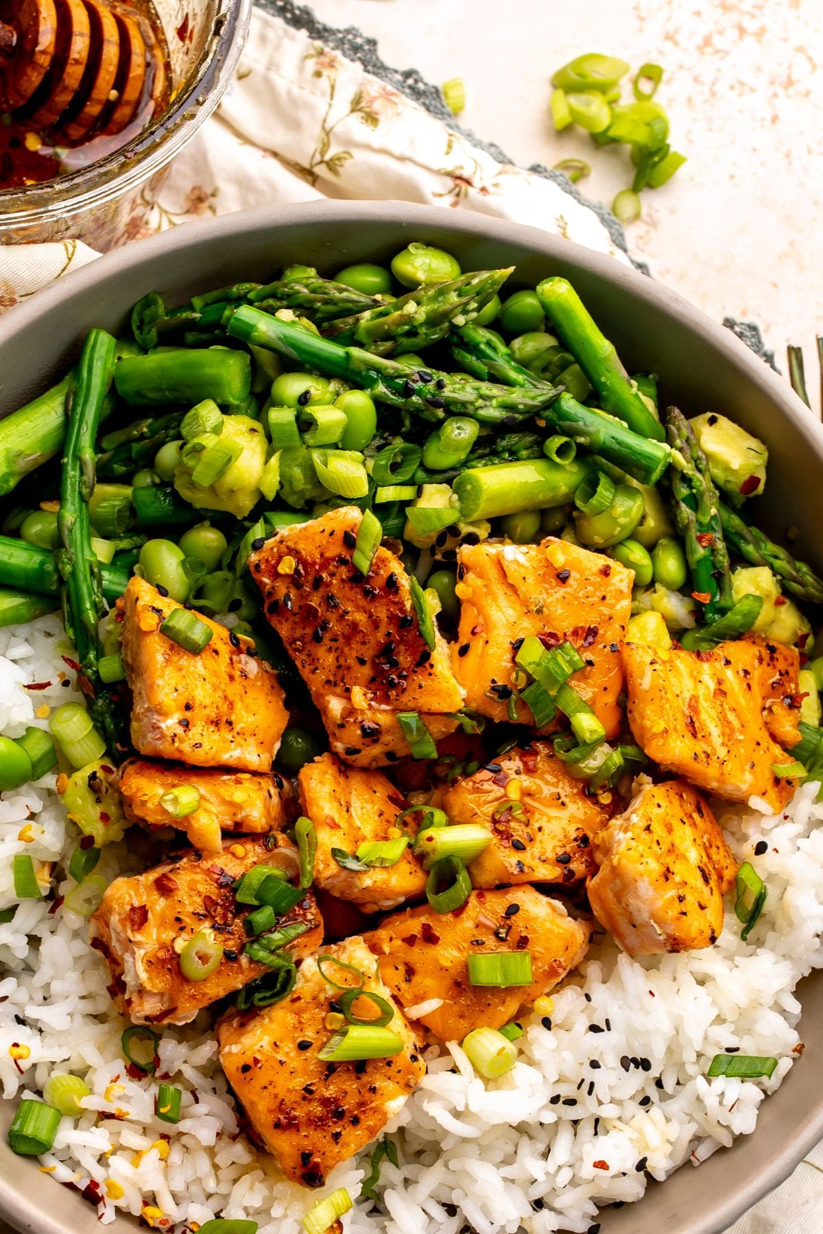 Hot Honey Salmon up close served over rice with veggies and green onions.