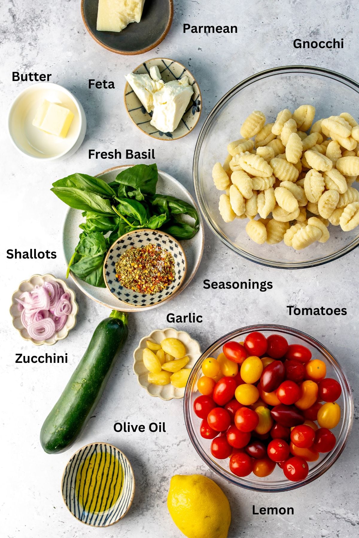 Ingredients needed to make this dish laid out on a counter in large glass bowls and colorful plates.