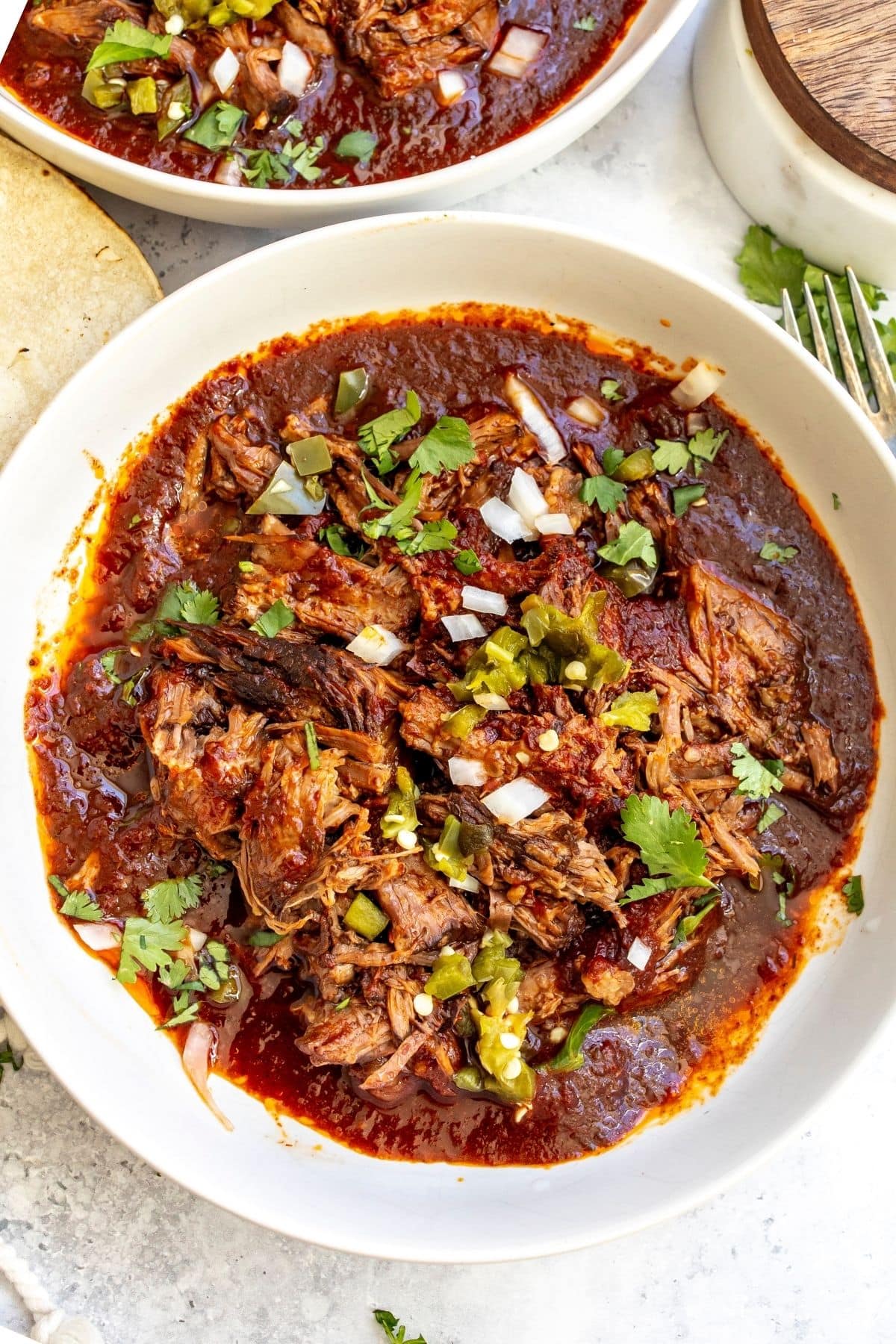 Slow cooker beef birria in a white bowl after cooking.