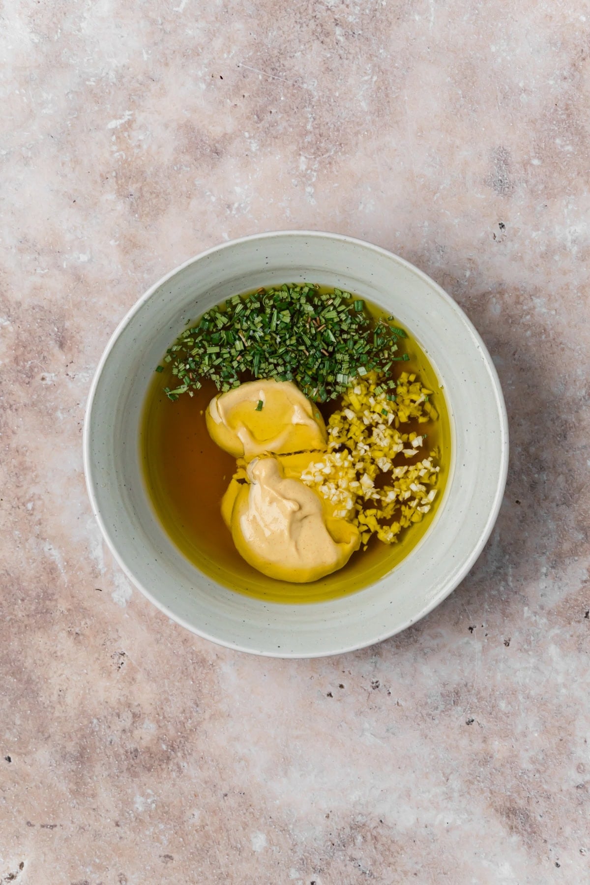 All of the ingredients for the maple Dijon sauce in a bowl before mixing.