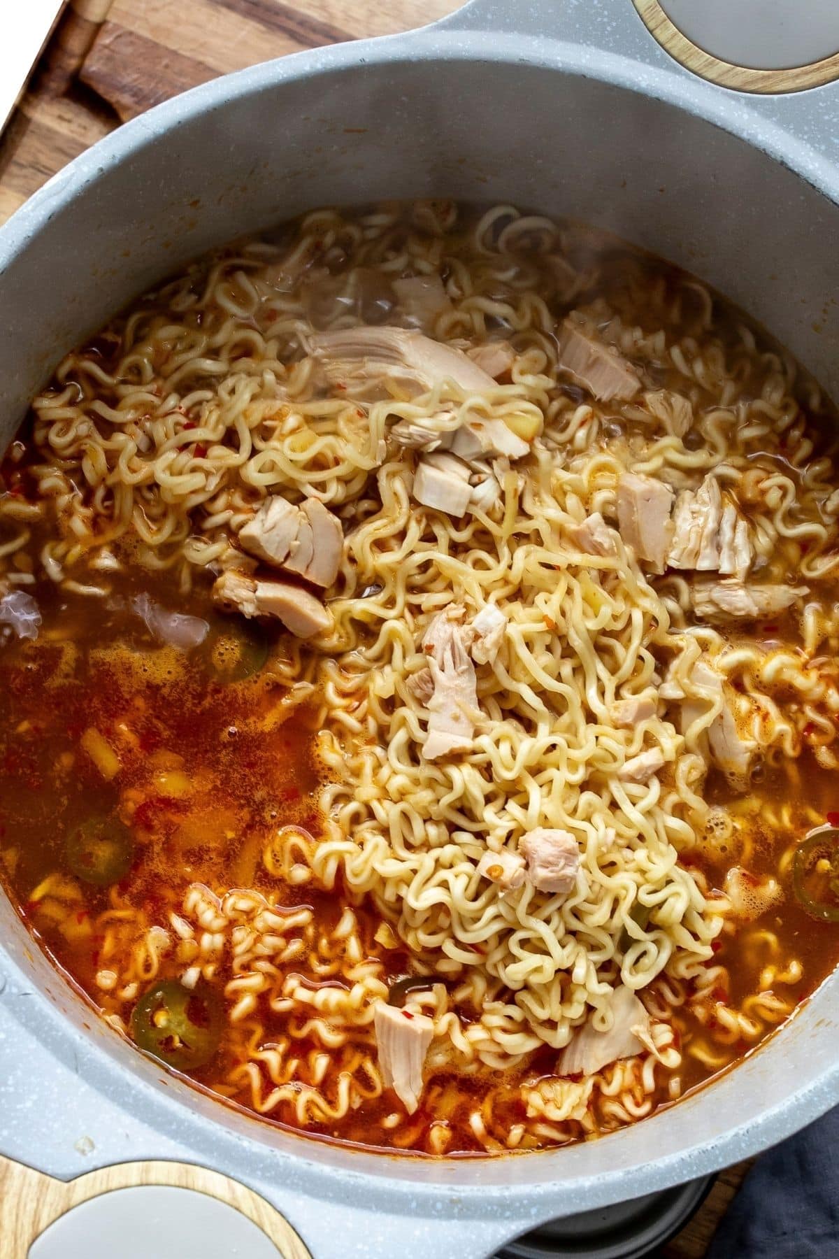 Ramen noodles and broth in a large soup pot.